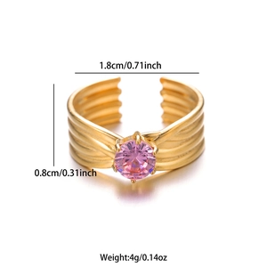 Detalle de anillo dorado con circón rosa y banda ancha con textura de ondas