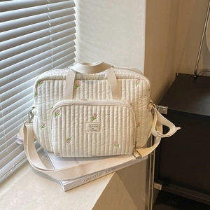 Sac à langer matelassé beige avec broderie de tulipes, incluant bandoulière et poignées