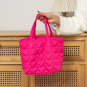 Detailed view of pink tote bag featuring heart quilted patterns and soft nylon texture