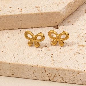 Polished gold butterfly earrings displayed on a natural stone background with light textures