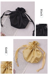 Detail view of satin drawstring storage bags in black and gold silky fabric