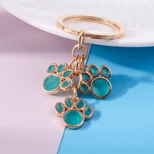 Detailed view of teal enamel cat paw pendants on a gold-plated metal keychain