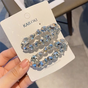 Set of two oval crystal hair clips with sparkling stones on a white display card
