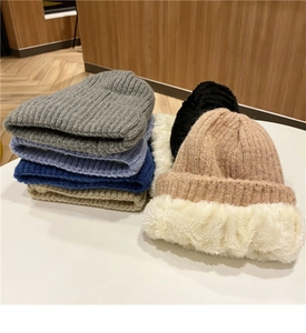 Dettagli di berretti invernali in maglia grossa multicolore con morbida fodera in pile
