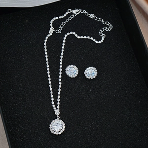 Detailed view of shimmering silver necklace and earring set with round pavé crystals
