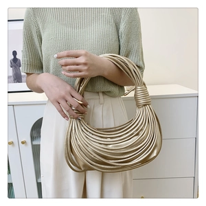 Vue détaillée du sac à main doré avec sa texture tressée multicouche élégante