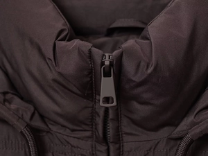 Detailed close-up of dark brown puffer jacket collar with premium matte zipper closure