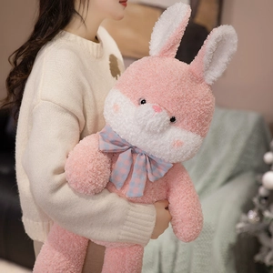 Pink plush rabbit doll with plaid bow tie and soft sherpa texture being held by a model