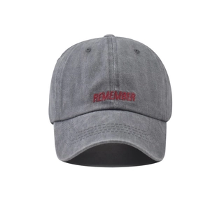 Detailed close-up of vintage washed grey cotton baseball cap with red embroidered letters