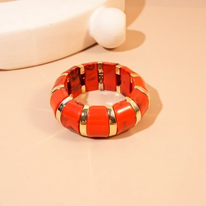 Detail of geometric acrylic resin bangle with orange marble texture and gold alloy metal