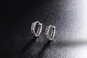 Macro detail of silver hoop earrings featuring vibrant square-cut multicolored zircons