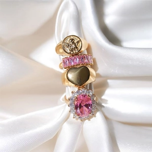 Pink zircon and 18K gold plated stainless steel heart rings set on white silk