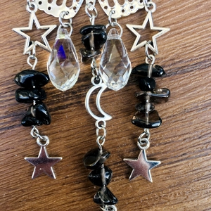 Macro detail of suncatcher pendant with silver stars, moon, and clear crystal drops