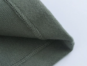 Close-up of grey-green fleece lining and professional stitching on the winter coat hem