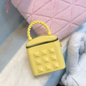 Mini yellow jelly bucket bag with pyramid studs and twisted handle for women