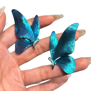 Elegant vintage blue butterfly stud earrings with iridescent metallic texture and gems