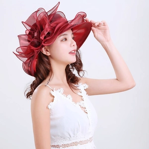 Detail of elegant red organza sun hat with large floral decoration for wedding events