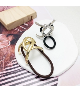 Minimalist U-shaped metal hair ties in gold and silver finish on a stone tray