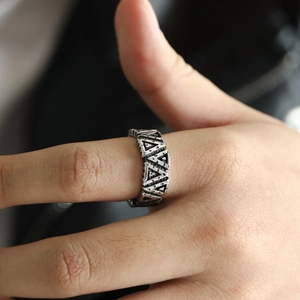 Macro detail of silver vintage Viking ring with geometric triangle hollowed out patterns