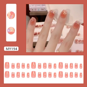 French cat-eye press-on nails with purple floral patterns and golden butterfly accents