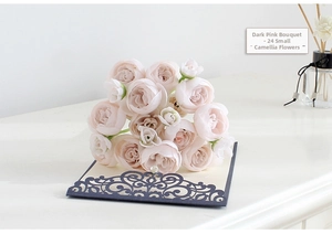 Detail of dark pink silk camellia bouquet with 24 heads on decorative blue card