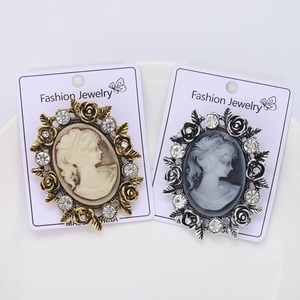 Detailed macro view of vintage cameo brooches in gold and silver with rhinestones