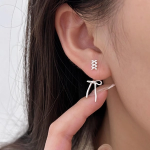 Minimalist 925 sterling silver bow knot stud earrings worn on ear for elegant style