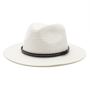 Detail of white woven straw fedora hat featuring black leather band with gold metal studs