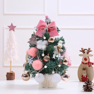 Mini pink Christmas tree with soft ornaments and wooden base for festive tabletop decoration