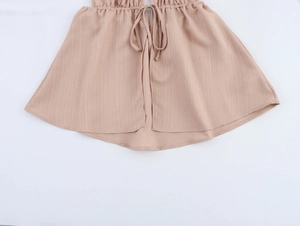Vue détaillée de l'ourlet en tissu beige texturé avec cordon de serrage décoratif chic