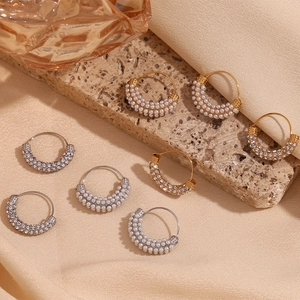 Macro view of gold and silver hoop earrings featuring micro-pave pearls and clear crystals