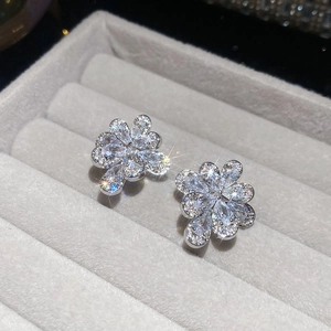 Close-up of silver flower ear clips with marquise-cut cubic zirconia on gray display box