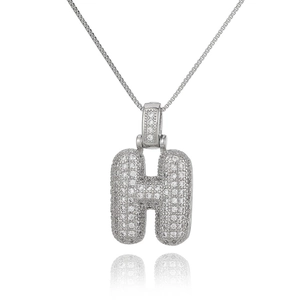 Detailed macro view of silver letter H pendant with micro-pave zircons and box chain
