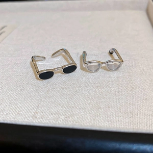 Detailed close-up of creative spectacle-shaped rings with black and clear lenses
