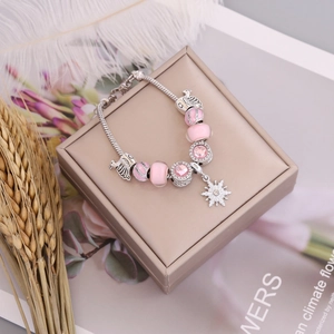 DIY silver snake chain bracelet with pink glass beads and a sparkling snowflake pendant