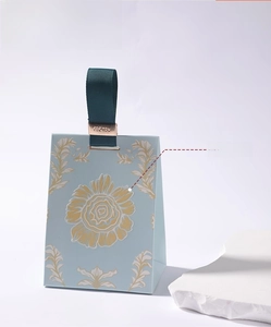 Detail of French floral wedding candy box with green ribbon and golden metal clip