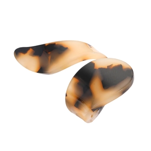 Close-up detail of tortoiseshell acetate C-shaped earrings with brown amber texture