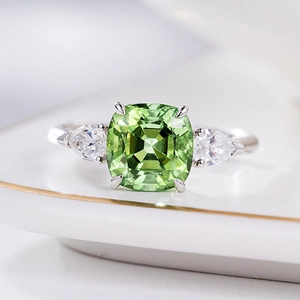 Anillo de plata de lujo con gema verde talla cojín y piedras laterales de pera