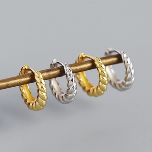 Macro shot of s925 silver croissant hoop earrings with twisted metallic texture design