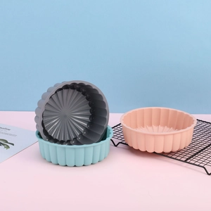 Three colorful silicone sunflower baking molds on a blue and pink two-tone background