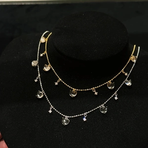 Elegant gold and silver heart necklaces set with ice-clear jade-style pendants on a display