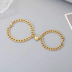 Detail of gold curb chain bracelets with heart-shaped magnetic clasp for couples