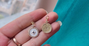 Close-up of circular star pendant with white enamel and blue gemstone inlay detail