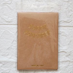 Detail of kraft paper Happy Birthday banner with gold foil letters in plastic packaging
