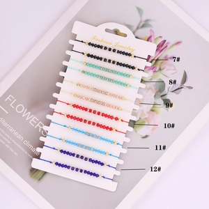 Detail of colorful crystal bead woven bracelets in six styles on a white display card