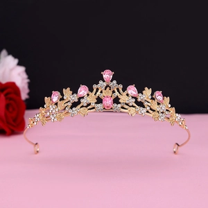 Detailed view of golden baroque tiara with pink crystals and intricate floral patterns