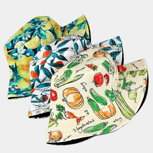 Detail of printed bucket hats featuring lemon, citrus, and vegetable patterns on canvas