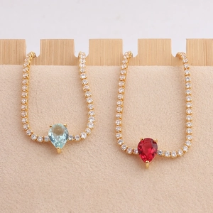 Gold tennis bracelet featuring teardrop blue and red gemstones with cubic zirconia accents