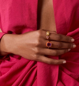 Close-up of three colorful enamel silver rings with geometric gemstones on hand