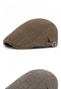 Close-up of herringbone tweed ivy caps in dark and light coffee with side metal buckles